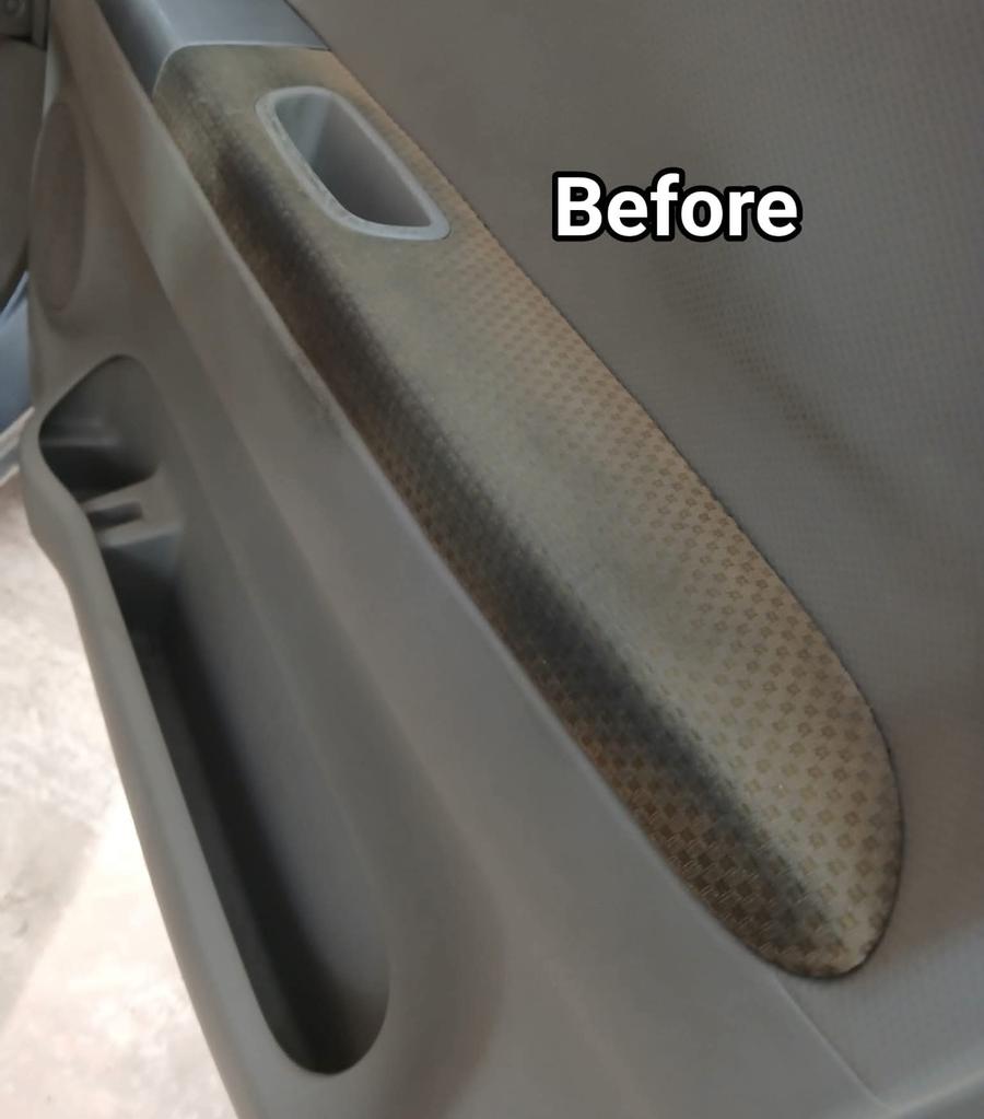 Stained fabric door armrest before cleaning