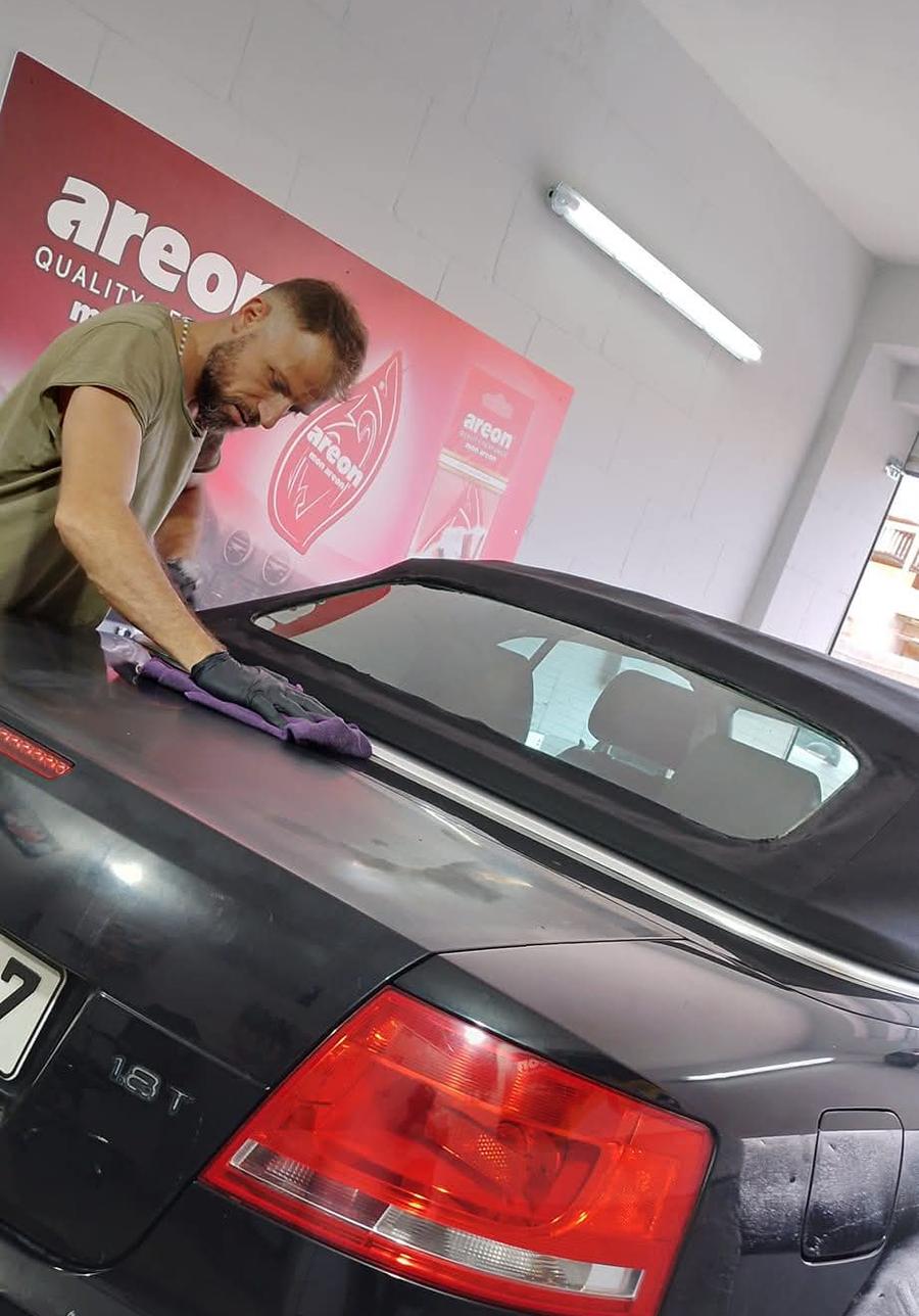 Francesco hand-finishing a black Audi convertible in the garage