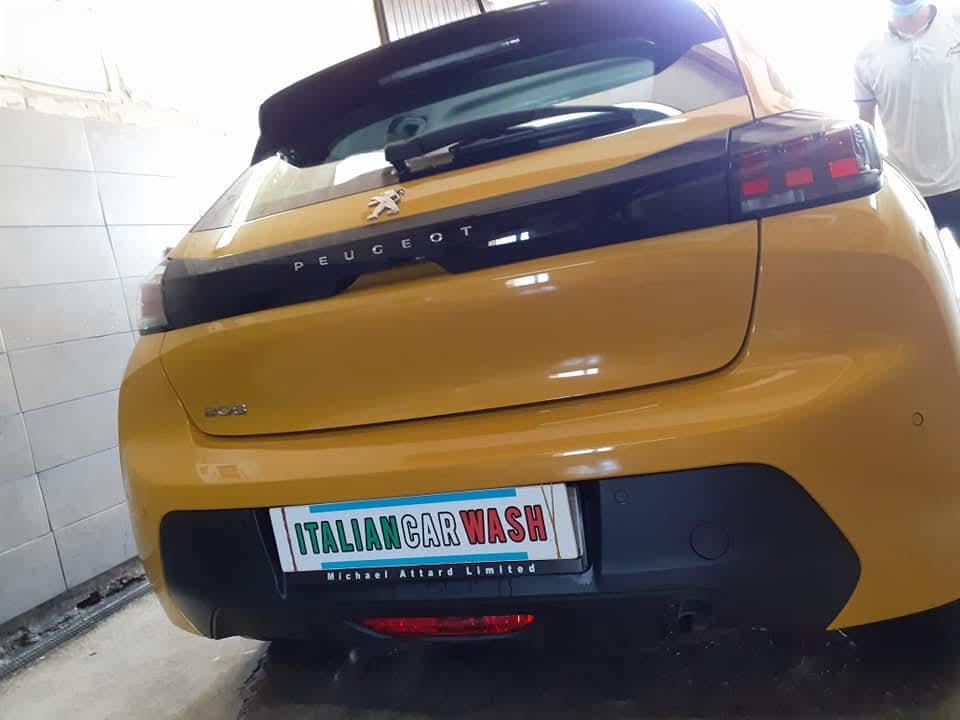 Yellow Peugeot 208 rear after a wash